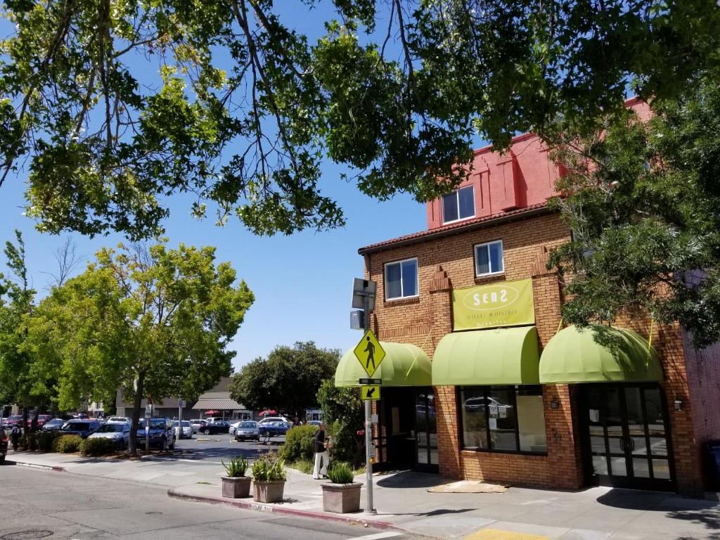 un edificio de ladrillo con una tienda con toldos verdes en SenS Hotel & Vanne Bistro Berkeley en Berkeley