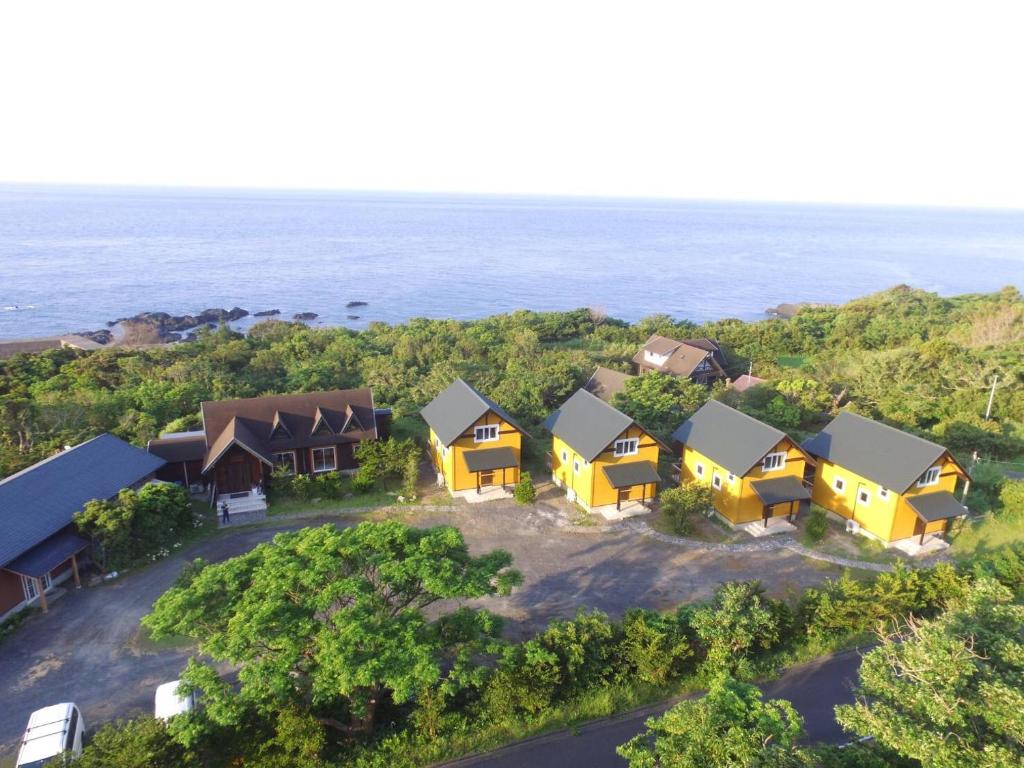 uma vista aérea de uma casa com o oceano ao fundo em TIDA Resort Yakushima 旧 屋久島海の胡汀路てぃーだ em Yakushima