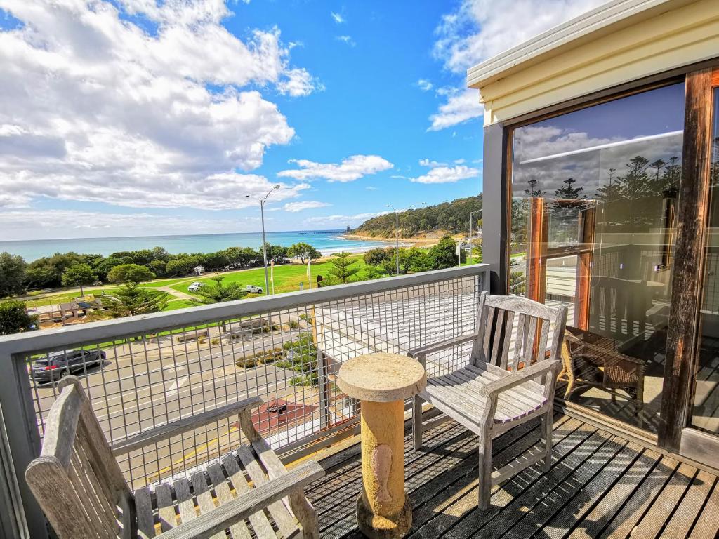 a balcony with two chairs and a table at Lornebeach Apartments in Lorne