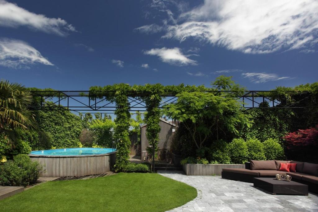 ロンメルにあるトゥインホテルのプールとパーゴラ付きの庭園