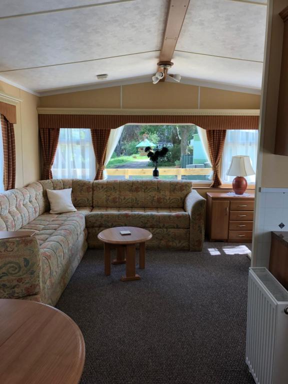 a living room with a couch and a table at 40 Glenfinart Caravan Park in Dunoon