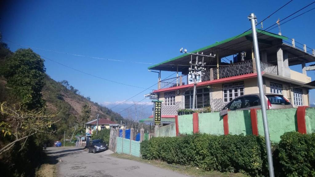 a building on the side of a street with a fence at Vamoose Newahang in Pedong