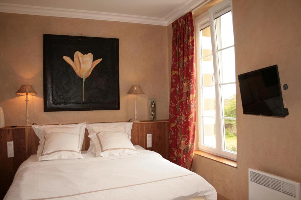una camera con un letto bianco e una finestra di Les 4 Tilleuls a Crozant