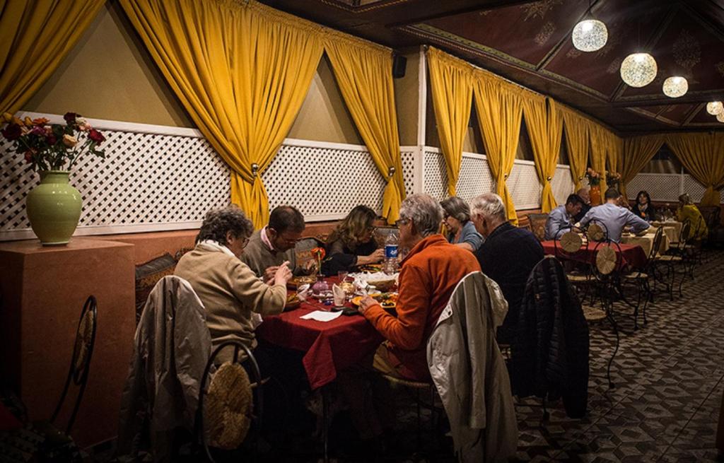 a group of people sitting at a table eating at Riad Challa Hotel & Spa in Marrakesh