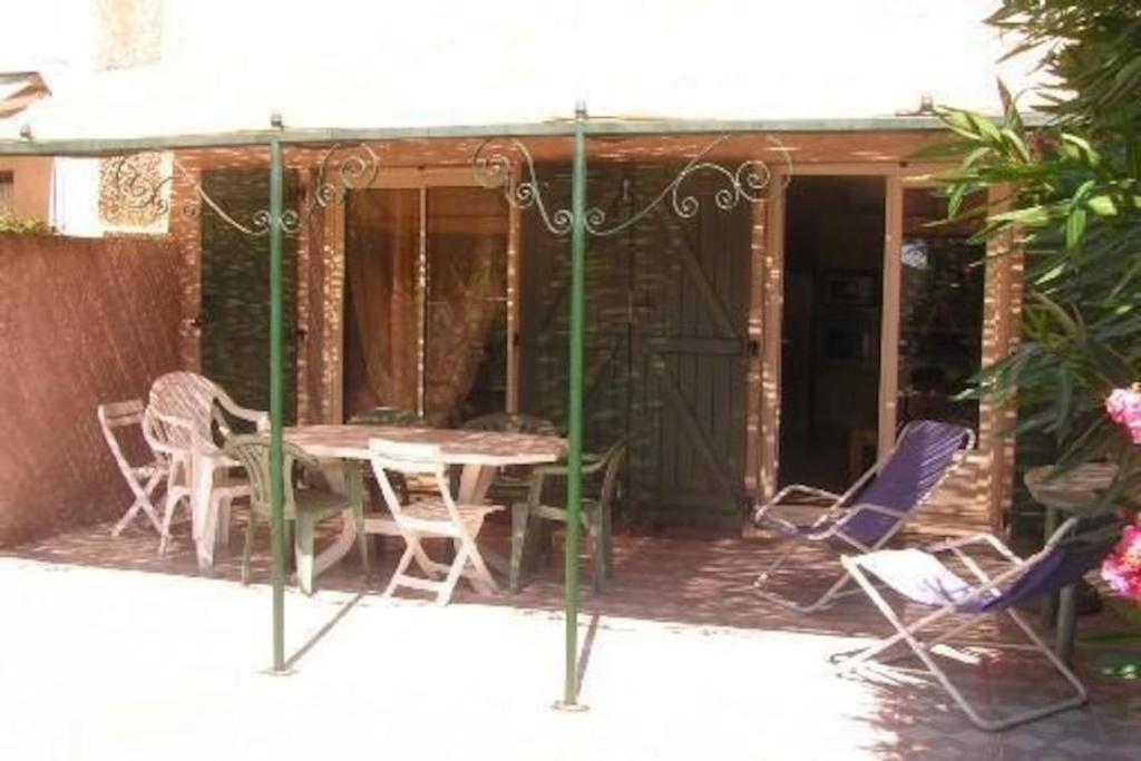 un patio avec une table et des chaises sur un porche dans l'établissement Maison Valras accès direct à la plage, à Valras-Plage