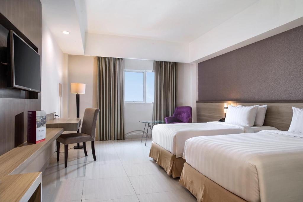 Postel nebo postele na pokoji v ubytování Swiss-Belinn Cibitung