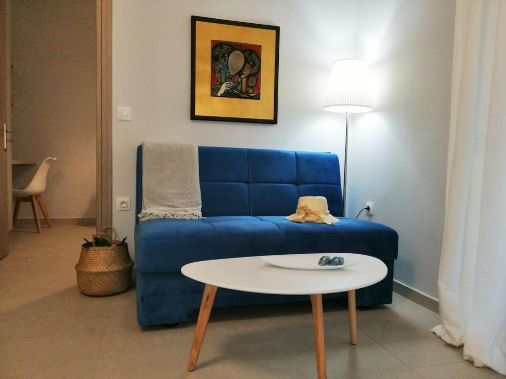 a living room with a blue couch and a table at Personal Holiday Homes in Rethymno Town