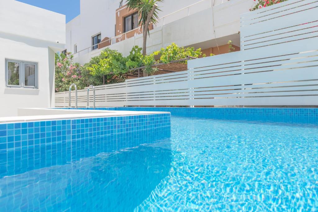 una piscina de agua azul frente a un edificio en Rotunda Suites en Kalamaki Chanion