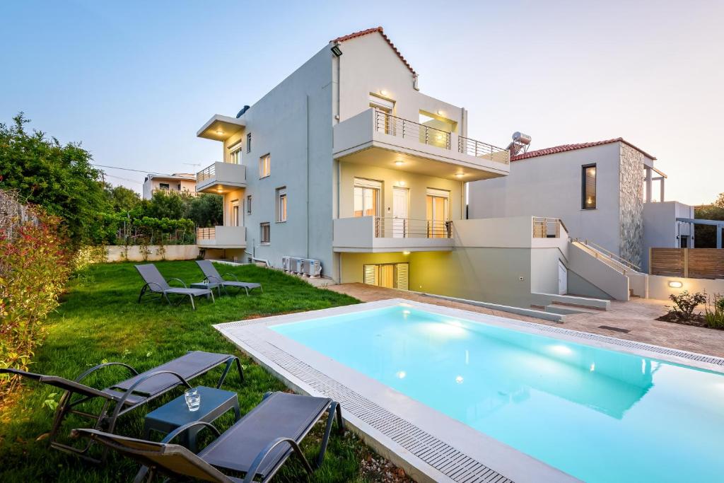 a villa with a swimming pool in front of a house at SP villa in Agios Onoufrios