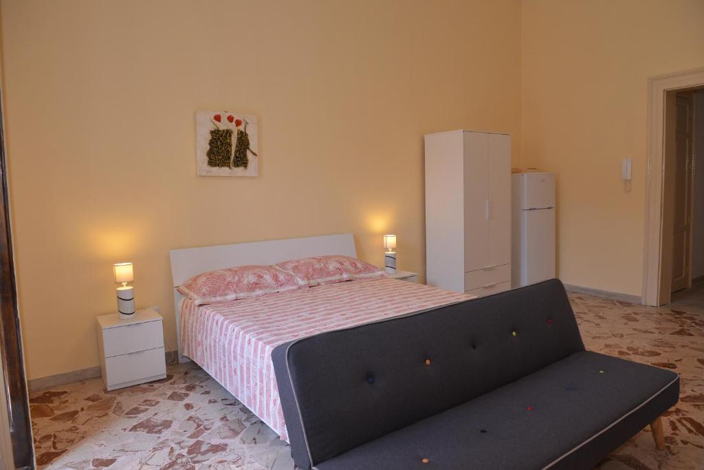 um quarto com uma cama e um sofá em strada del corso da Alberto em Avola