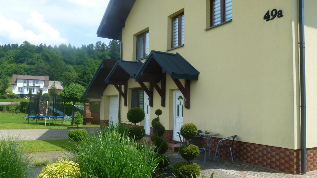 a house with black awnings on the side of it at Apartament Bieszczady in Myczkowce