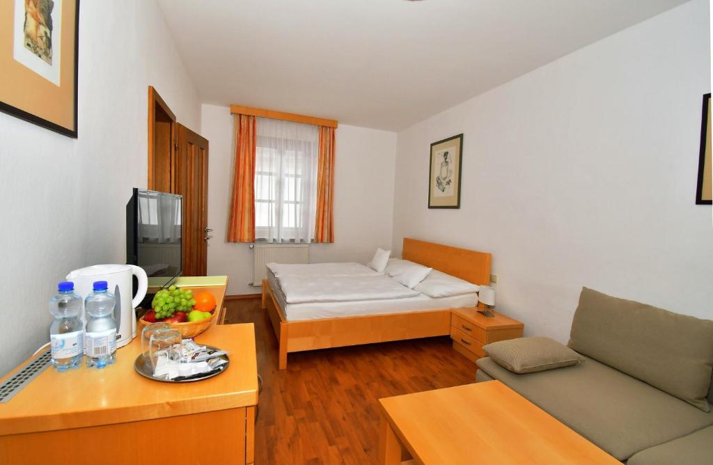 een kleine woonkamer met een bank en een bed bij Penzion na Ostrově in Český Krumlov