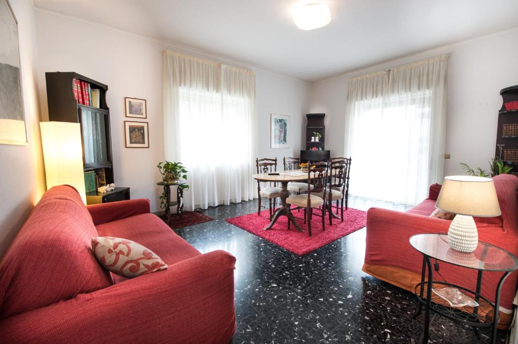 Appartamento Signorile AMBIENTI SANIFICATI في مسينة: غرفة معيشة بها كنبتين حمراء وطاولة