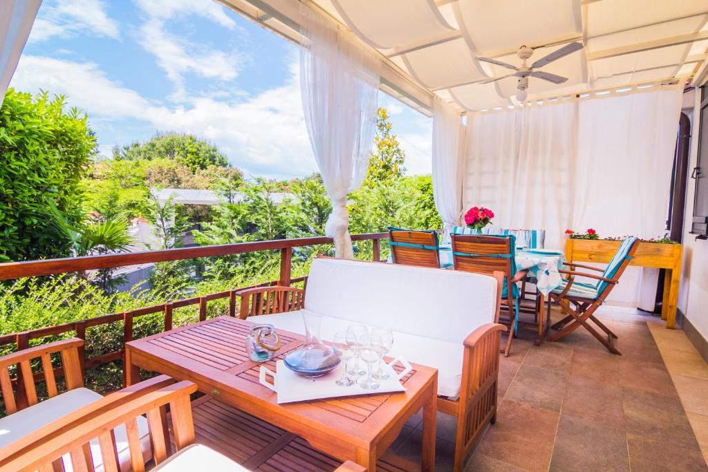 a patio with a table and chairs on a balcony at Pure relax by the forest in Vinkuran