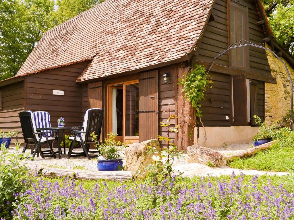 een hut met een tafel en stoelen ervoor bij Magnificent holiday home with pool in Thenon in Thenon