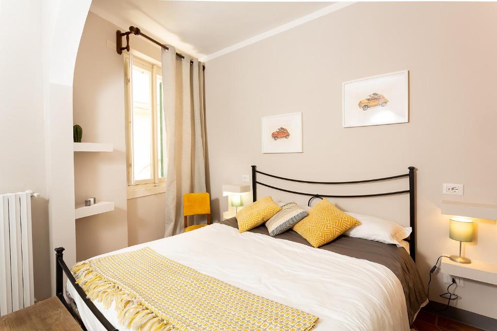 a bedroom with a large bed with yellow pillows at Casa Dreosti in Cortona