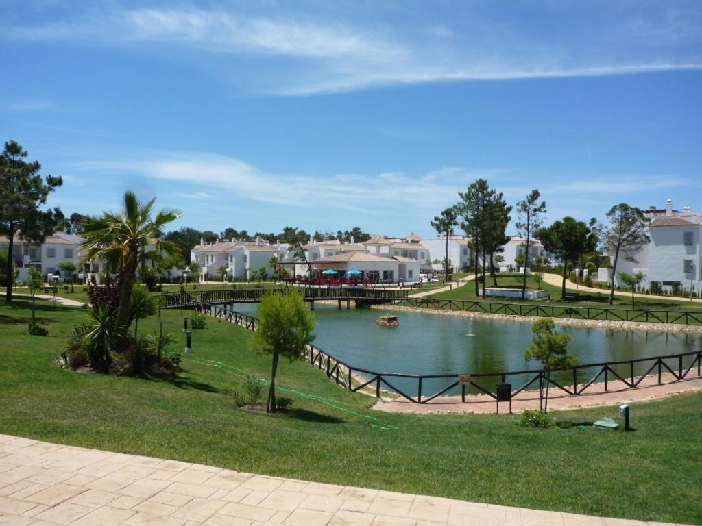 un estanque en un parque con árboles y casas en Hacienda Golf Islantilla, en Islantilla