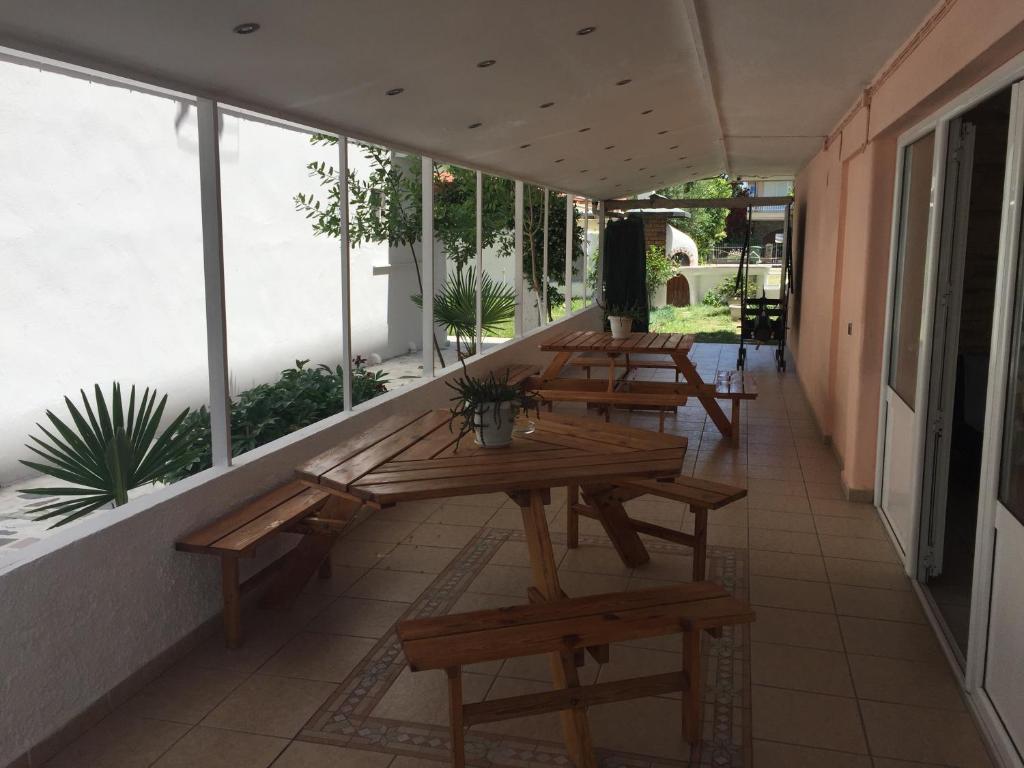 a row of picnic tables on a balcony with windows at Dimis Studios and Apartments in Olympic Beach