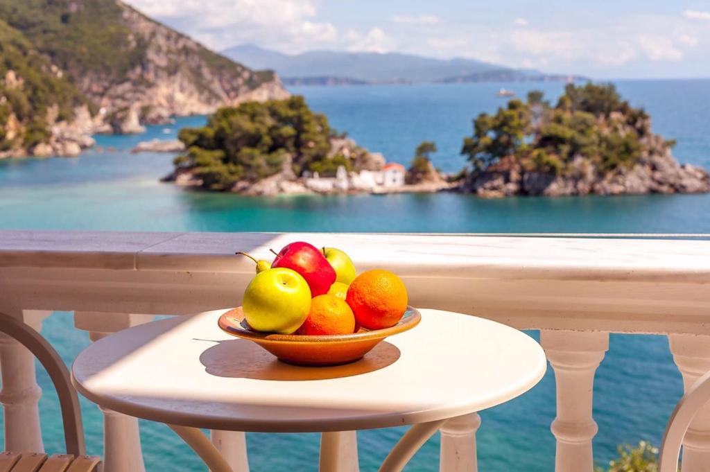a bowl of fruit on a table on a balcony at Alekas Parga Apartments in Parga