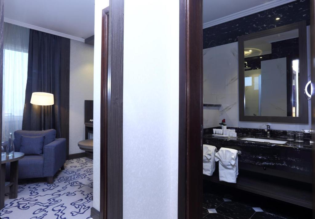 a hotel room with a sink and a mirror at Swiss Flora Royal Hotel Riyadh in Riyadh