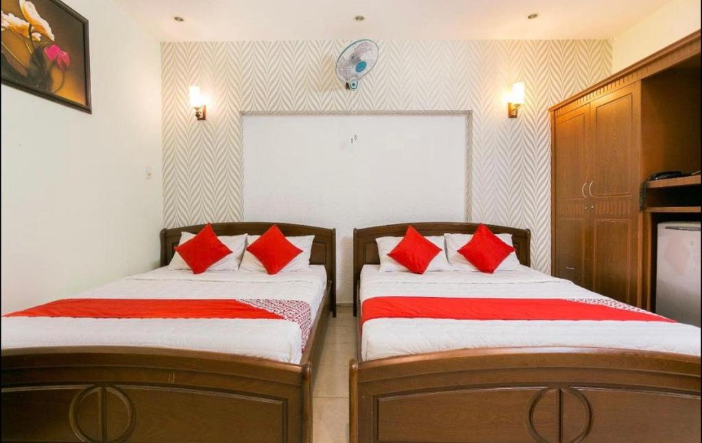 2 camas en una habitación con almohadas rojas en Nhà Nghỉ Trà My, en Như Thức