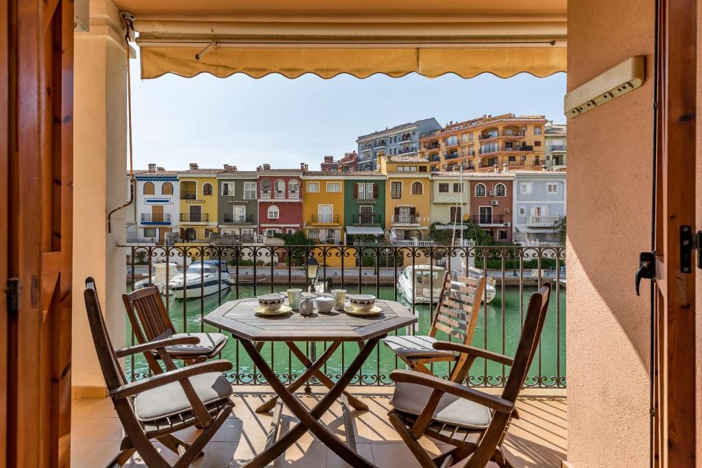 a table and chairs on a balcony with a view of a city at Beach Apartment with beautiful view in Port Saplaya