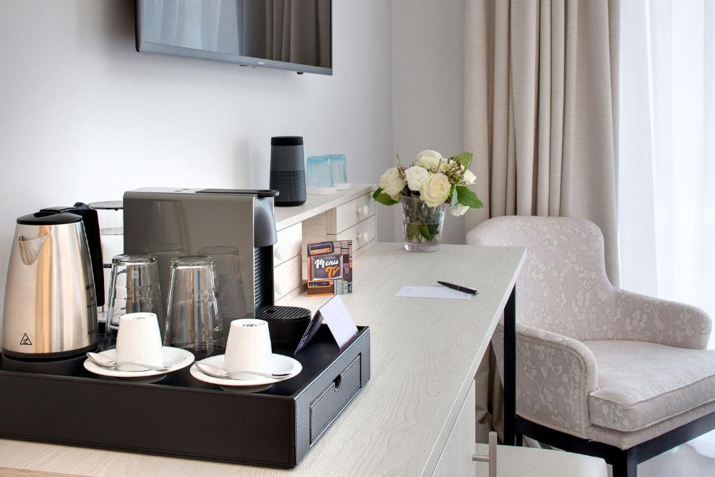 a kitchen with a table with a coffee maker and a chair at La Bastide de Biot in Biot