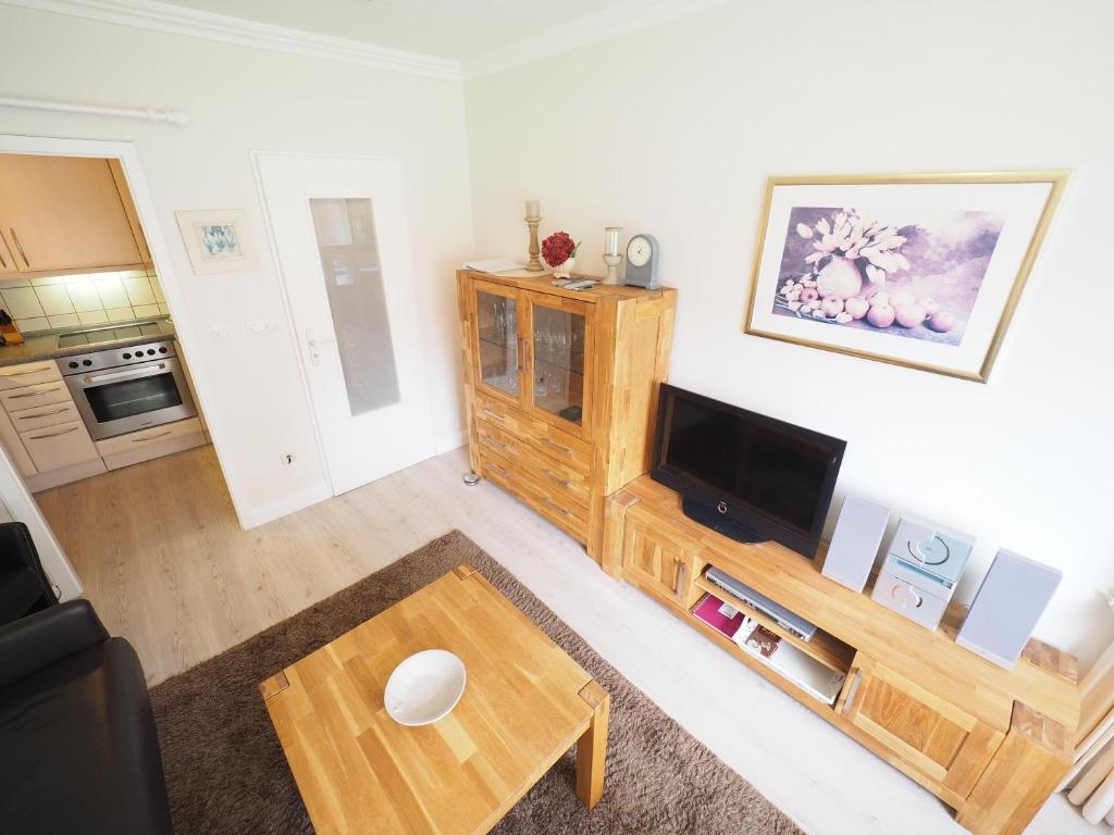 uma sala de estar com uma televisão e uma mesa em Appartement-167 em Westerland