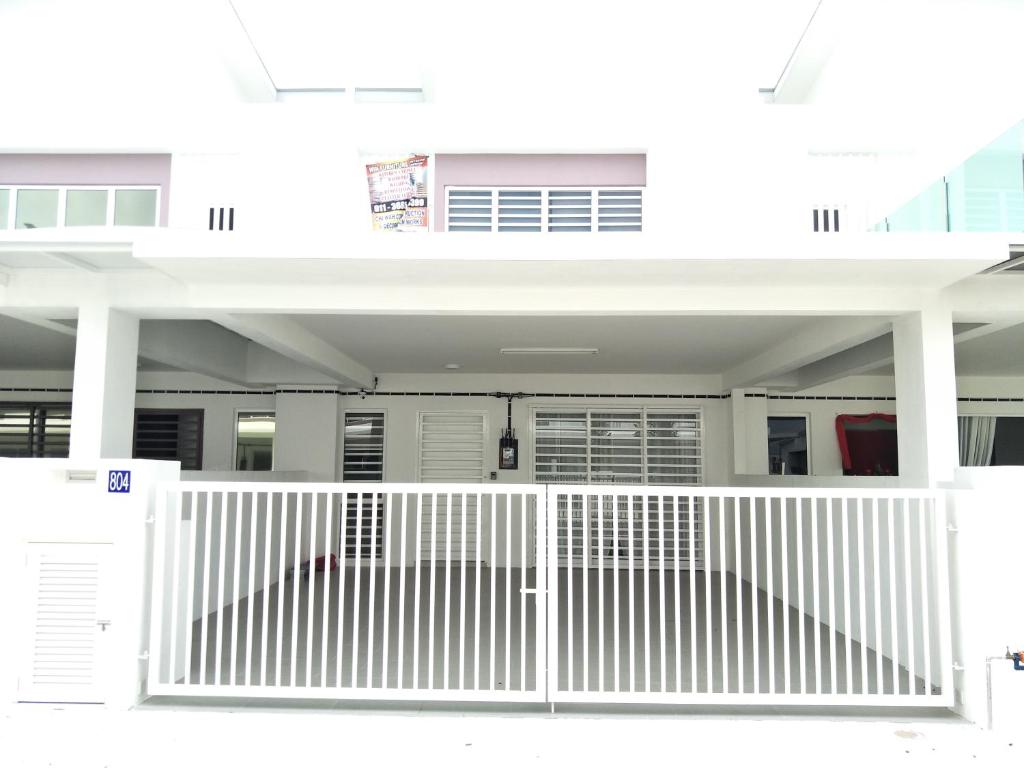 a white house with a white gate at Holiday Homestay Seremban in Seremban