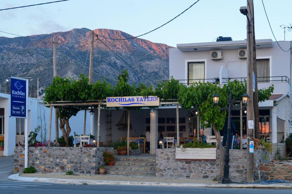 a building with a sign in front of a mountain at Rooms Kochilas Elafonisi in Elafonisi