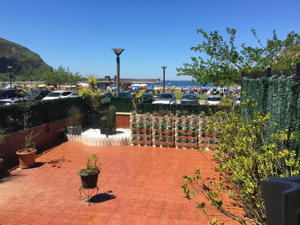 a brick patio with potted plants and a parking lot at ORIO PLAYA in Orio