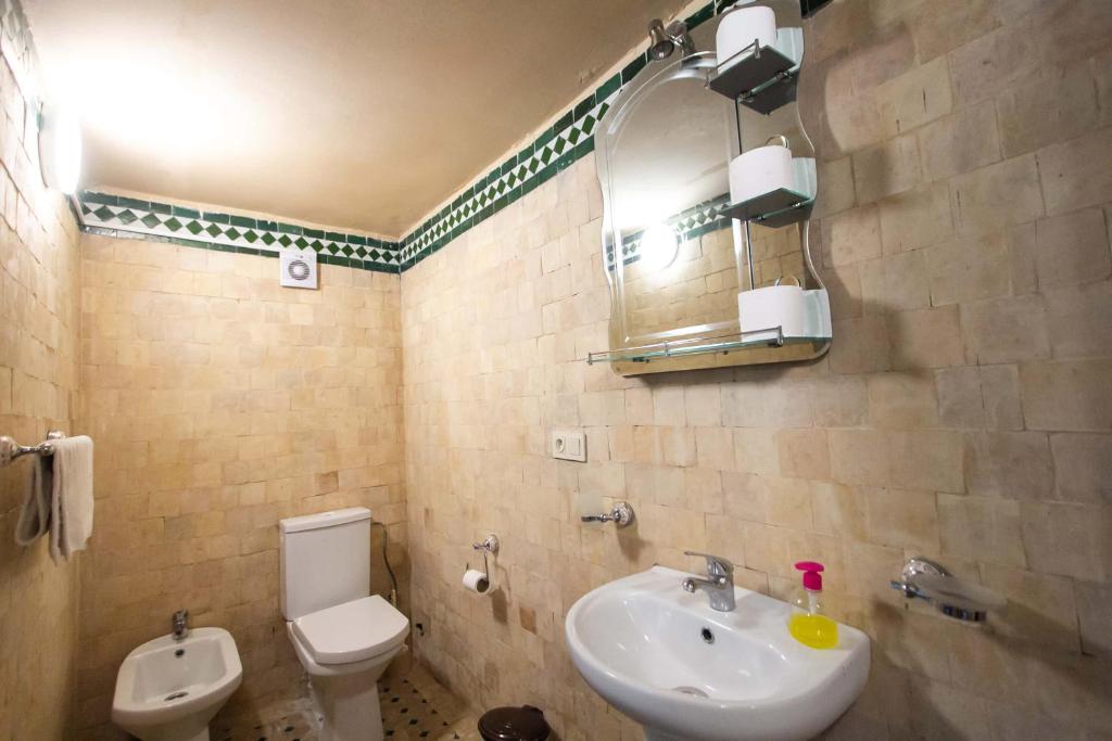 y baño con lavabo, aseo y espejo. en Hostel Amir, en Fez