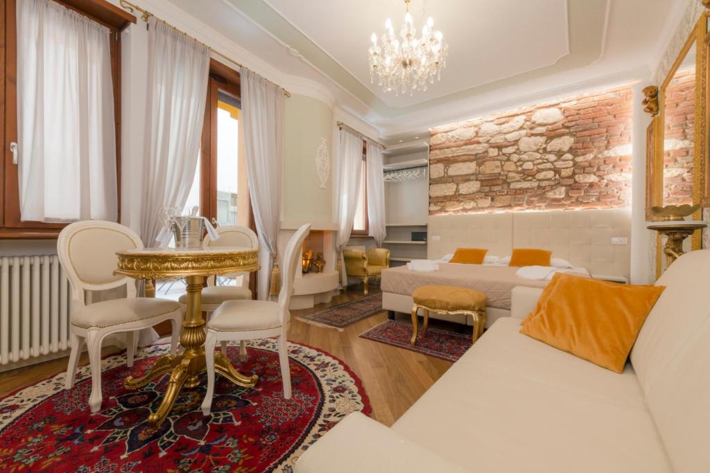 un soggiorno con divano e tavolo di Royal Giardini dell'Arena Relais - Royal Welcome a Verona