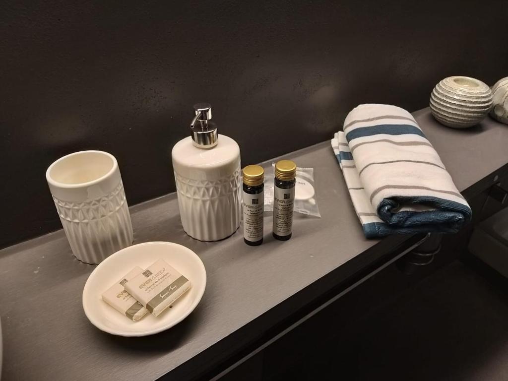 eine Badezimmertheke mit zwei Flaschen und einem Handtuch in der Unterkunft Modena Charme Sant'Eufemia in Modena