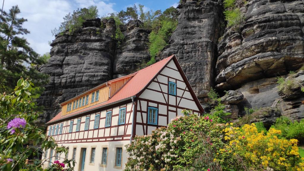 uma casa em frente a uma montanha em Ferienwohnungen Felsenkeller Bielatal em Bielatal