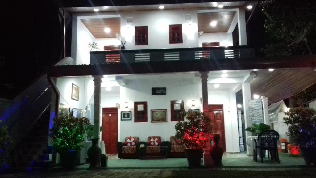 a white house at night with people standing in front of it at The Green Village Dambulla in Dambulla