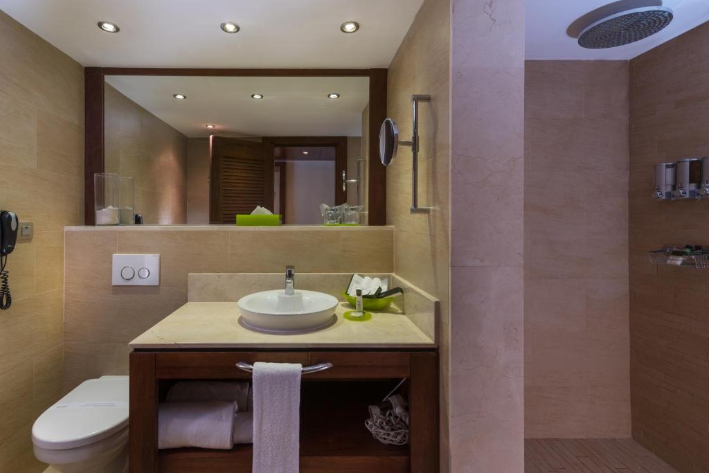un bagno con lavandino, water e specchio di Barceló Bávaro Beach - Adults Only All Inclusive a Punta Cana