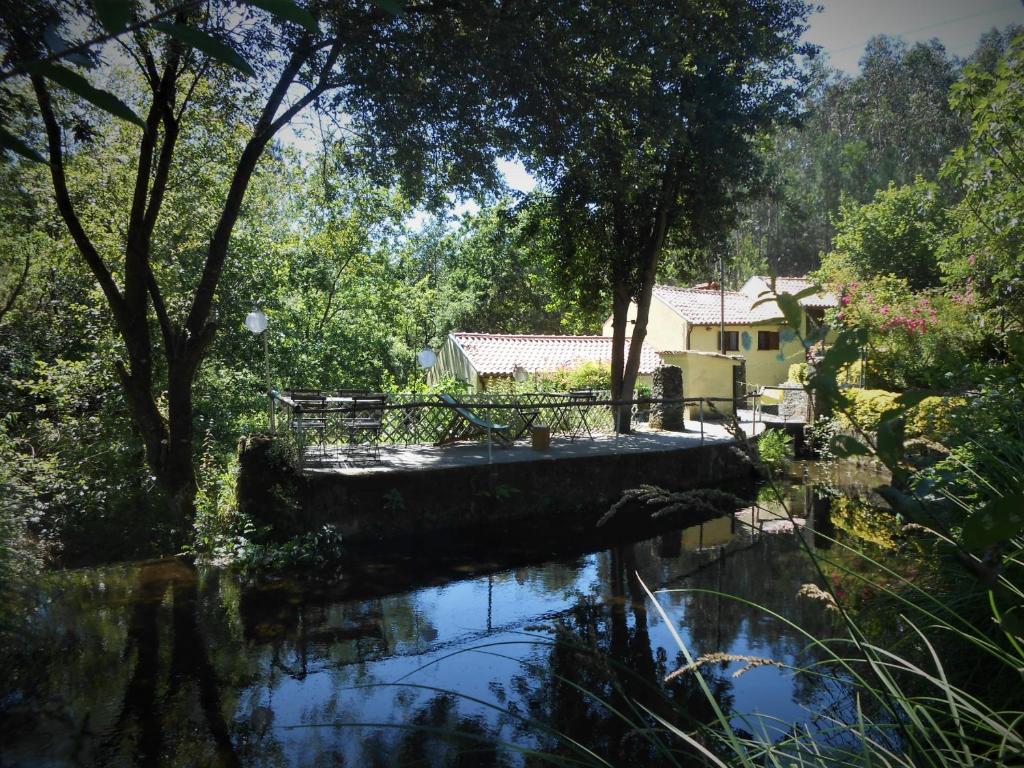 a body of water with trees and a house at Watermill Moinho Garcia in Pinheiro da Bemposta