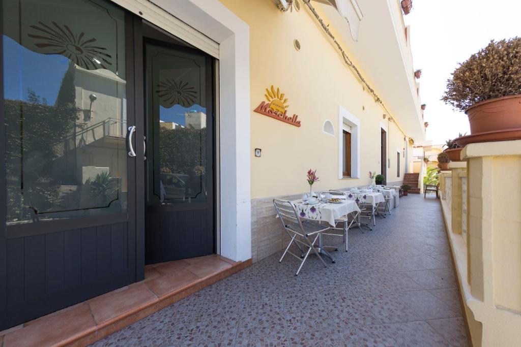 une terrasse avec une table et des chaises à l'extérieur d'un bâtiment dans l'établissement Albergo Moschella, à Lampedusa