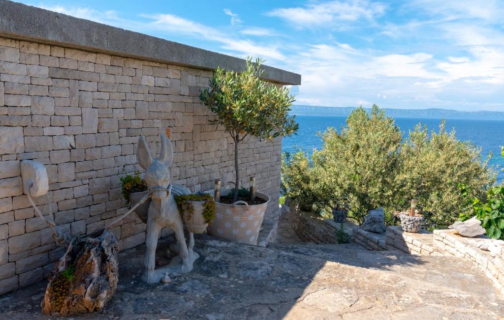 a statue of a rabbit sitting next to a brick wall at Apartman Sunrise in Vela Luka