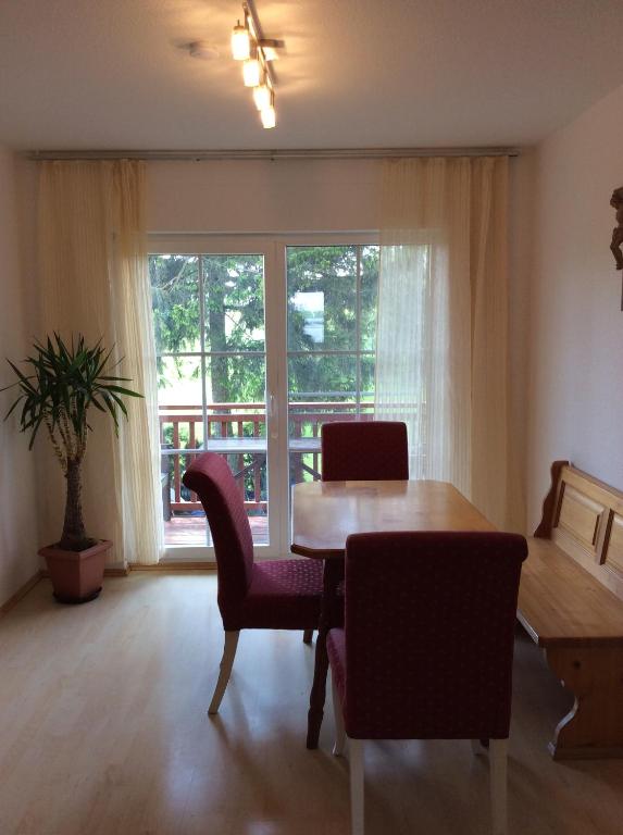 a dining room with a table and chairs and a window at Haus Willer in Erding