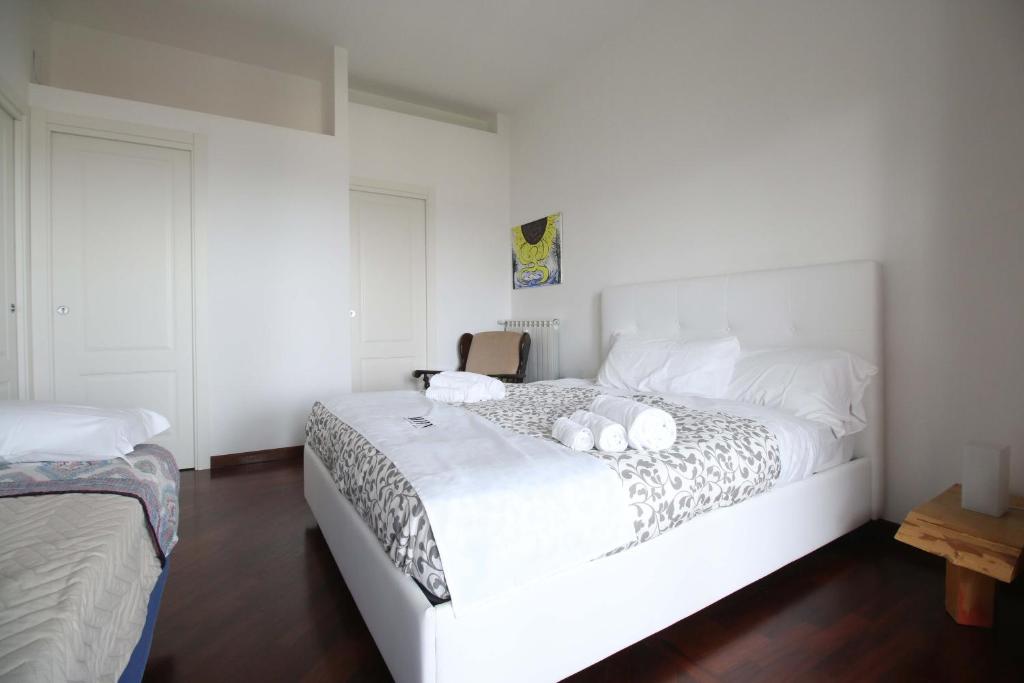 una camera da letto con un letto bianco con due peluche sopra di Oasi Relax Manzoni by HHN a Napoli