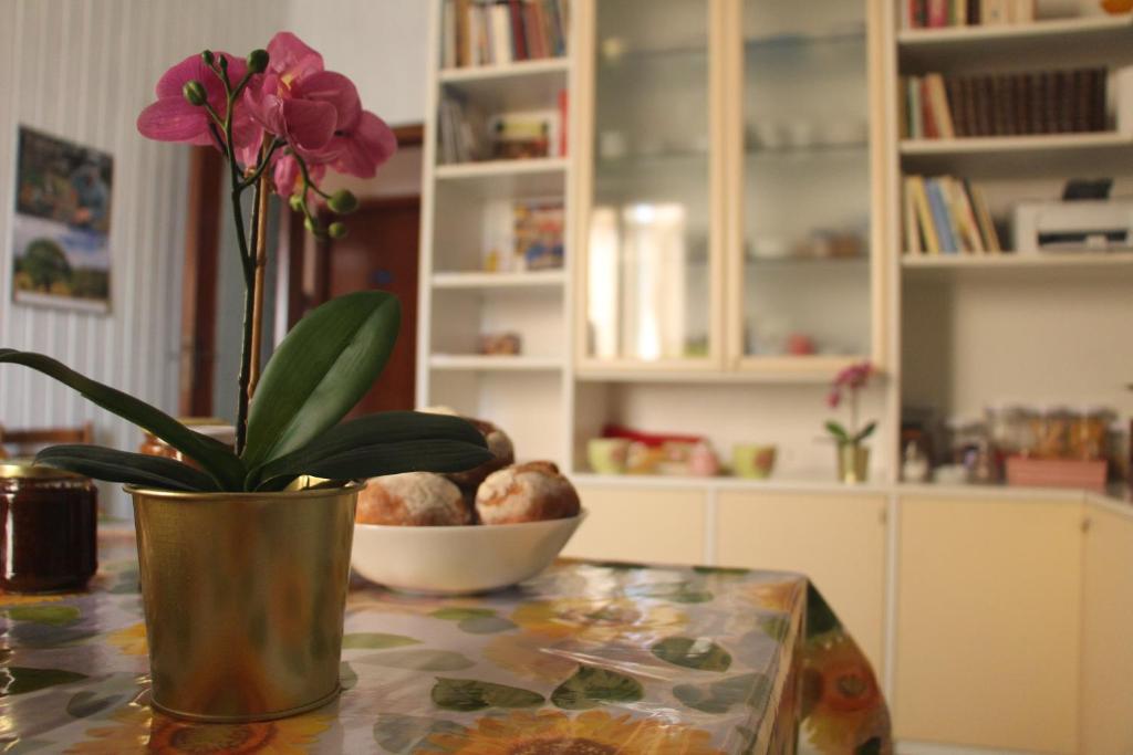 un jarrón con una flor en una mesa con un tazón en Gottardo, en Monserrato