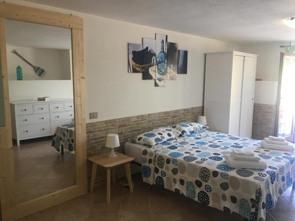 - une chambre avec un lit et un miroir dans l'établissement B&B Tavolara, à Puntaldia