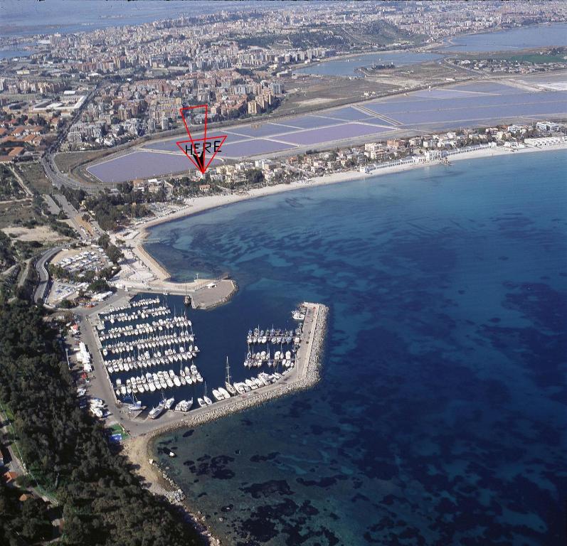 czerwony latawiec latający nad wodą w obiekcie Lewis Rooms Poetto Beach w Cagliari