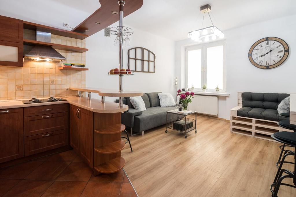 uma cozinha e sala de estar com um relógio na parede em THE HEART OF NOWA HUTA - free garage na Cracóvia