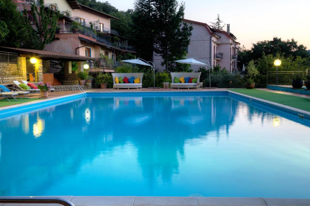 une grande piscine d'eau bleue en face d'un bâtiment dans l'établissement Hotel Sa Muvara, à Aritzo