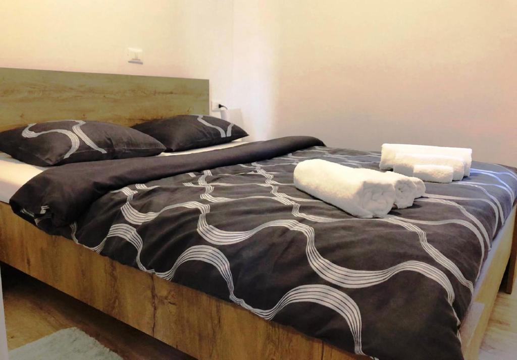 Cama grande con mantas y almohadas blancas y negras en MONTE B. Exclusive Apartment, en Rovinj