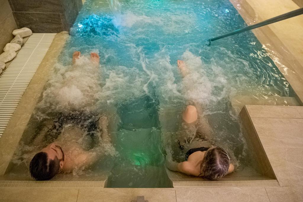 un par de personas en una piscina en Hotel Lory My Wellness SPA, en Chianciano Terme