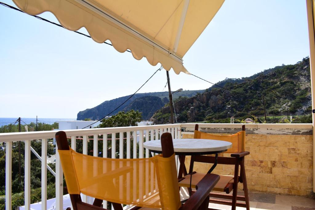 un tavolo e sedie su un balcone con ombrellone di Marinakis Sea View Studios a Soúgia